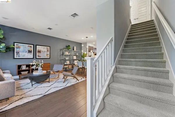 a living room with furniture and stairs