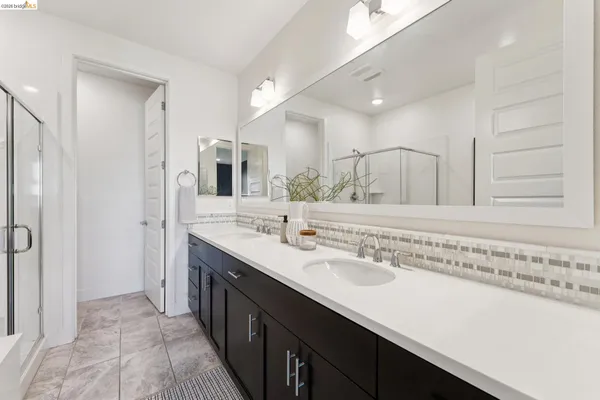 a en suite bathroom with a double vanity sink a mirror and a shower