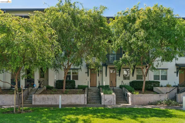 a view of a big house with a big yard and large trees