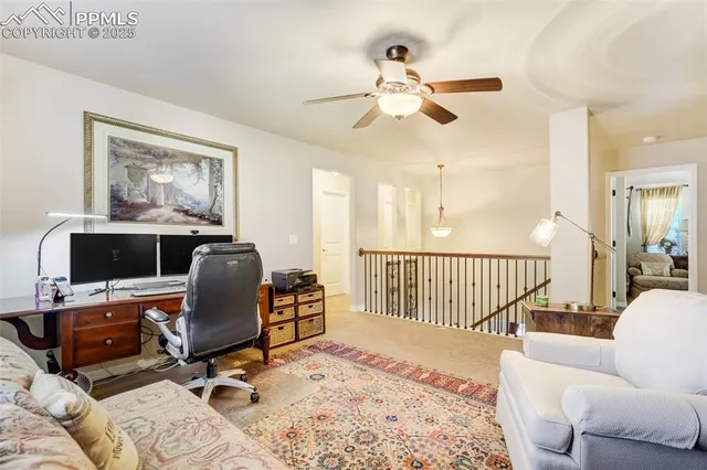 a view of a workspace with furniture and a window