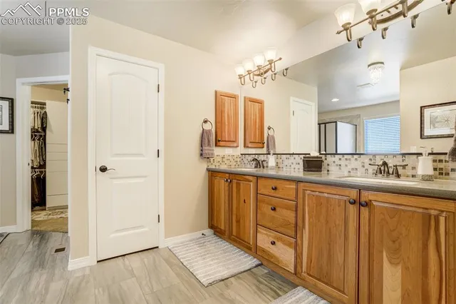 a spacious bathroom with a granite countertop sink mirror and a shower