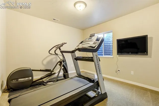a room with gym equipment and flat screen tv