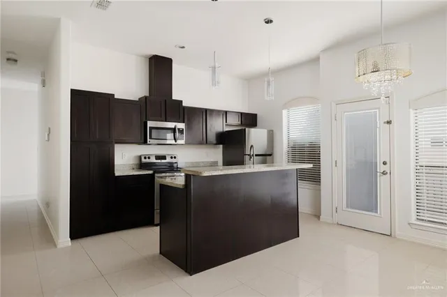 a kitchen with kitchen island granite countertop cabinets and stainless steel appliances