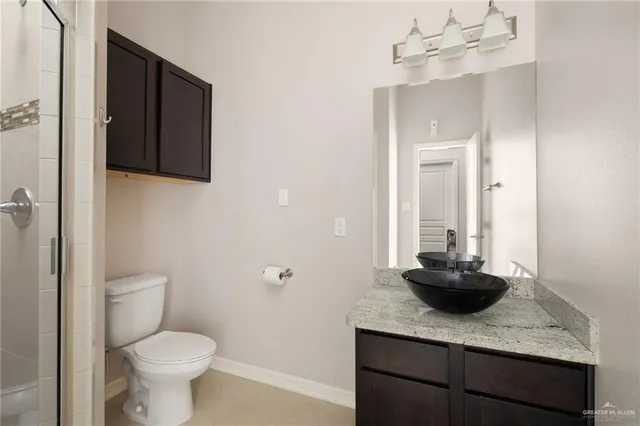 a bathroom with a granite countertop sink a toilet and mirror