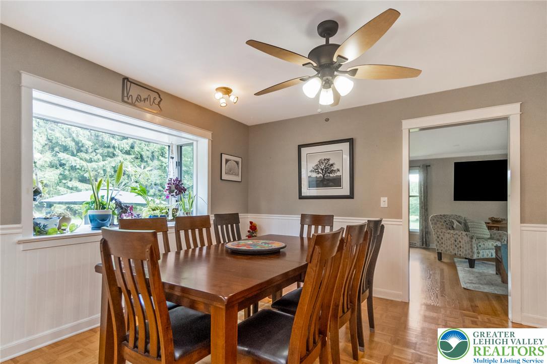 1553 Surrey Road Bethlehem, PA 18015 - Photo 12 of 92 A well-lit dining area features warm wood floors and a bay window overlooking lush greenery.