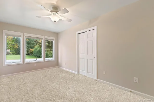 an empty room with a window and a fan