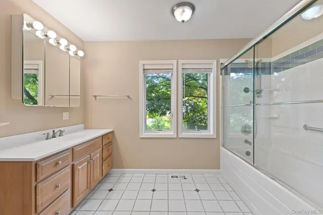 a spacious bathroom with a granite countertop sink a mirror and a shower