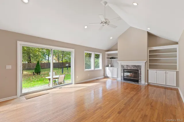a view of empty room with wooden floor and fireplace