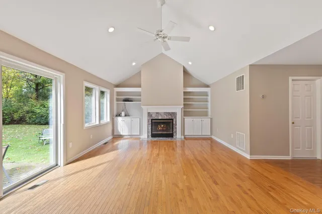 a view of a livingroom with a fireplace wooden floor and window