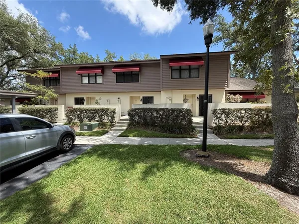 a view of a house with backyard and sitting area