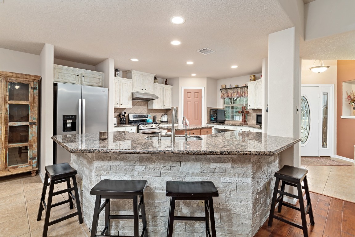 4985 Fm 2827 Road Warren, TX 77664 - Photo 11 of 41 a kitchen with stainless steel appliances granite countertop table chairs sink and cabinets
