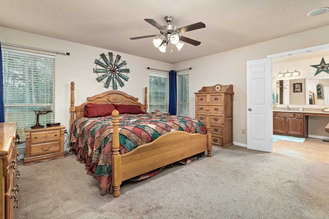 4985 Fm 2827 Road Warren, TX 77664 - Photo 16 of 41 a bedroom with a large bed and a chandelier