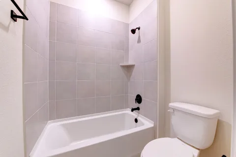 a white bath tub sitting next to a white toilet