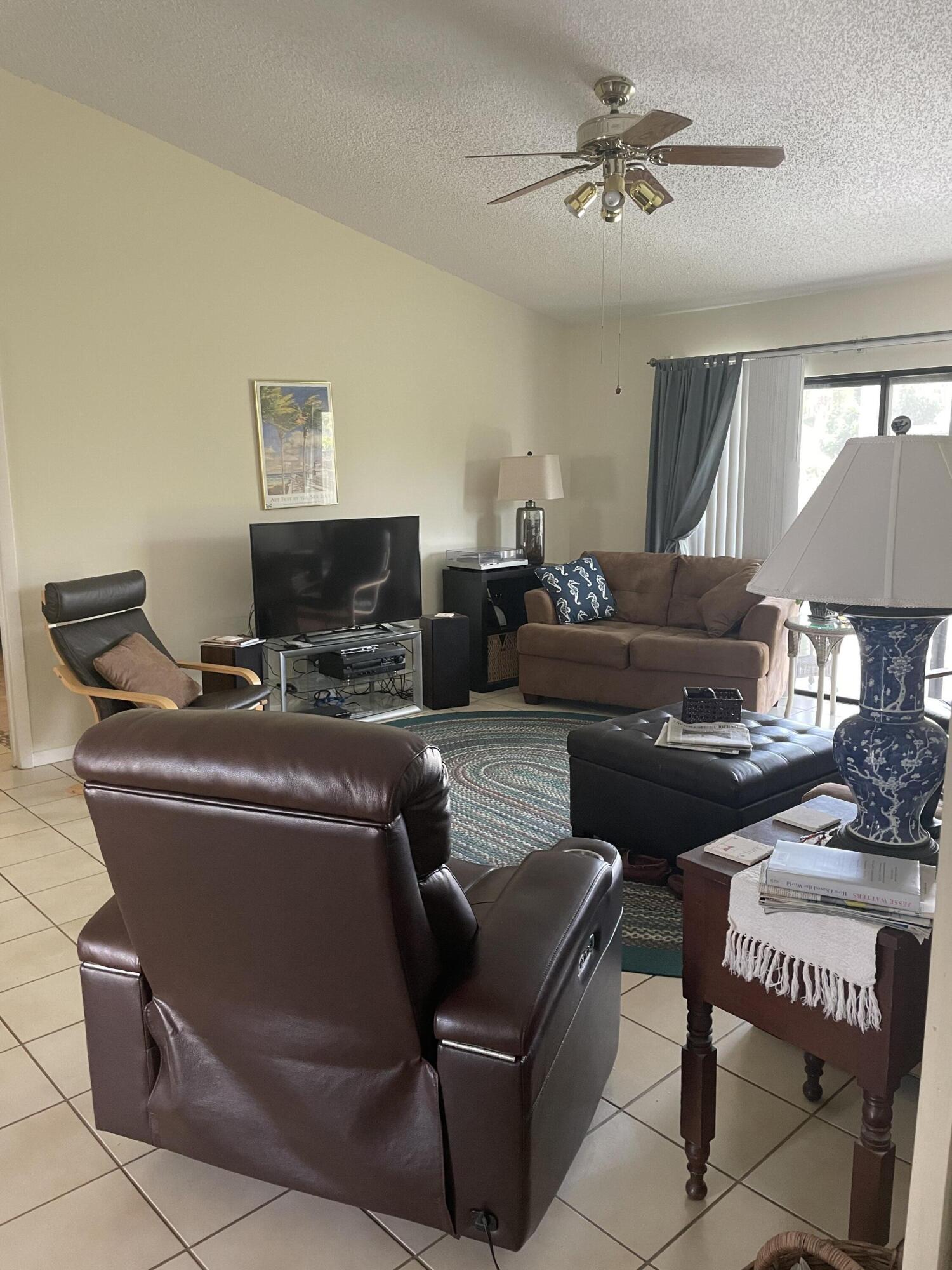 108 Greenbriar Drive Jupiter, FL 33458 - Photo 6 of 8 a living room with furniture and a lamp