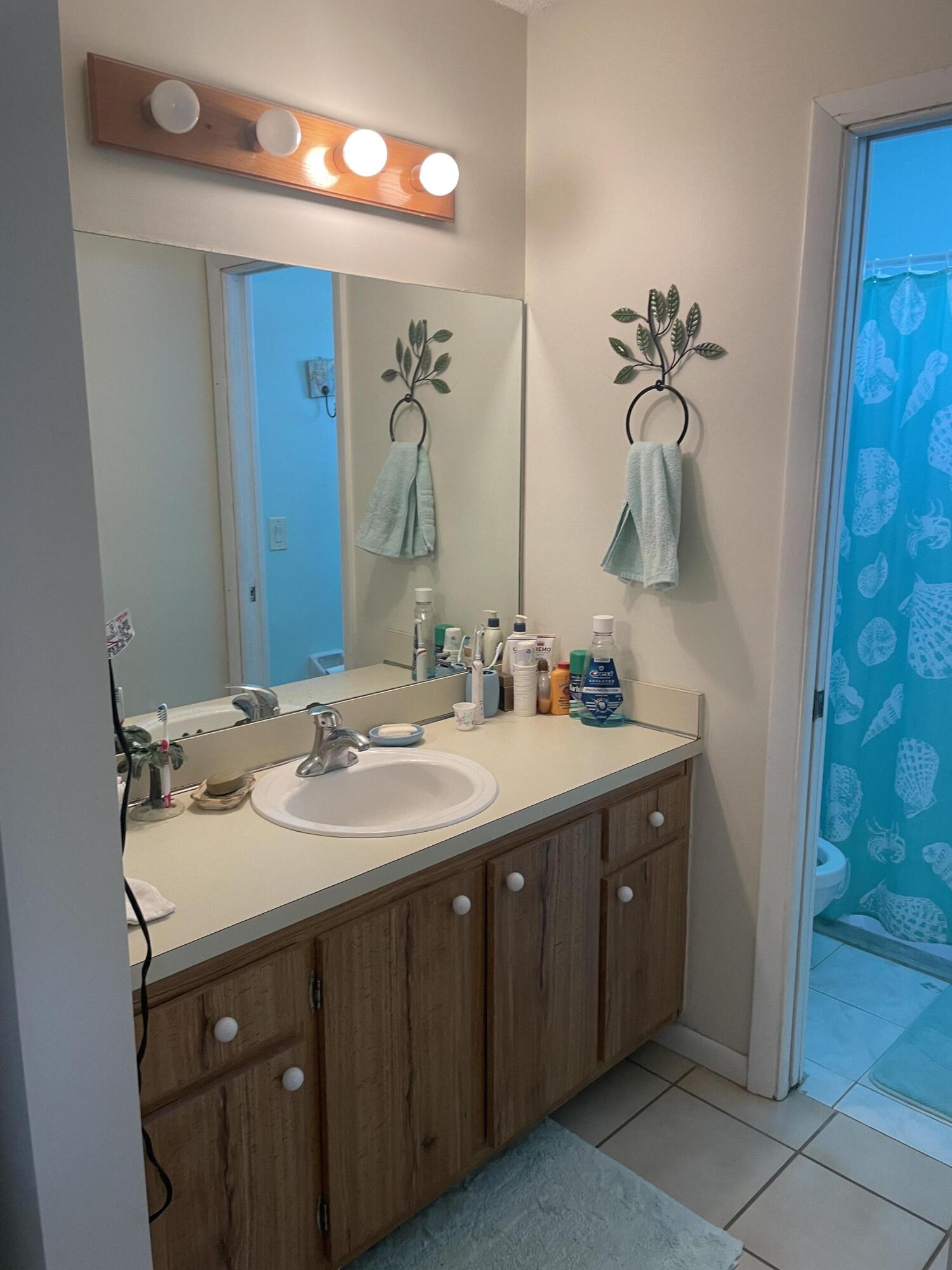 108 Greenbriar Drive Jupiter, FL 33458 - Photo 7 of 8 a bathroom with a double vanity sink and a mirror