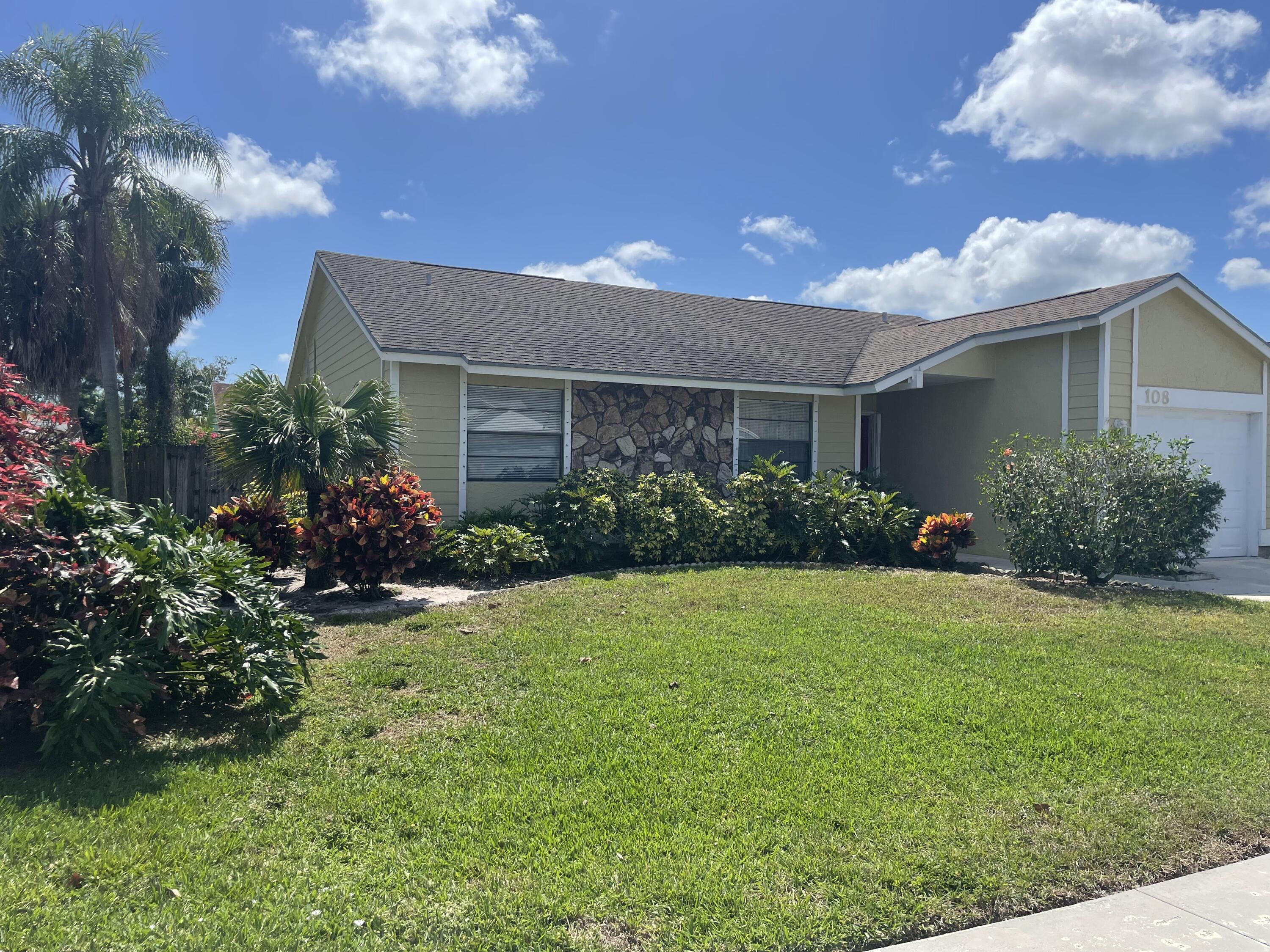 108 Greenbriar Drive Jupiter, FL 33458 - Photo 8 of 8 a front view of house with yard and green space