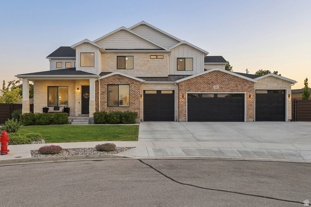 10676 Urban Rdg Cove South Jordan, UT 84095 - Photo 1 of 48 Contemporary exterior featuring a stone and brick facade with vertical white siding accents