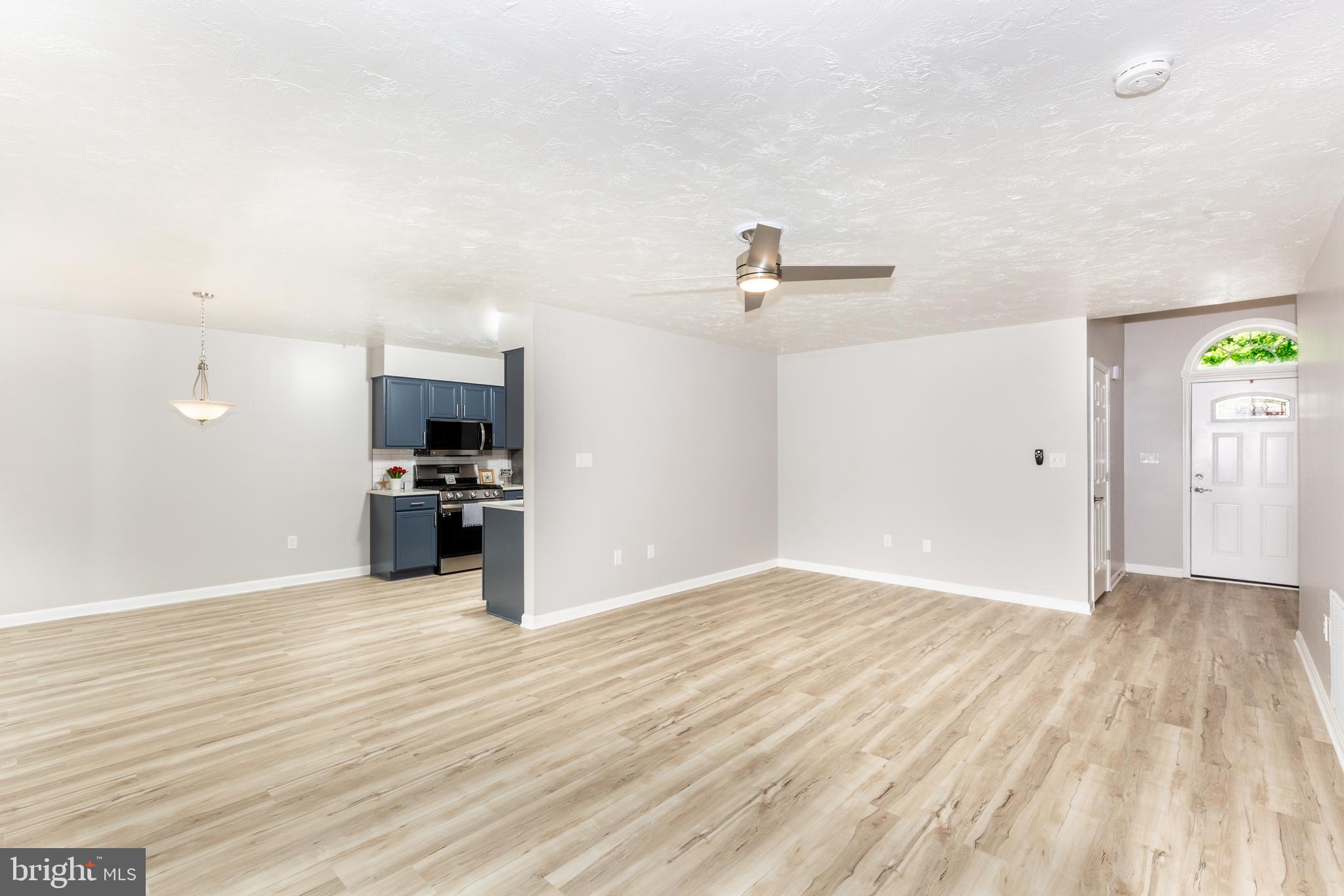 159 Colorado Avenue Littlestown, PA 17340 - Photo 11 of 47 a view of kitchen and empty room with wooden floor