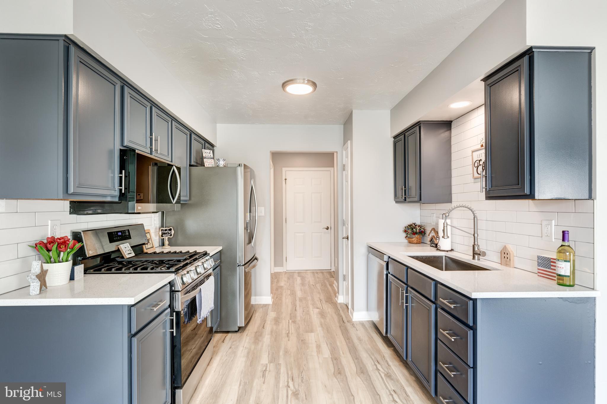 159 Colorado Avenue Littlestown, PA 17340 - Photo 16 of 47 a kitchen with granite countertop a sink dishwasher stove and refrigerator with wooden floor