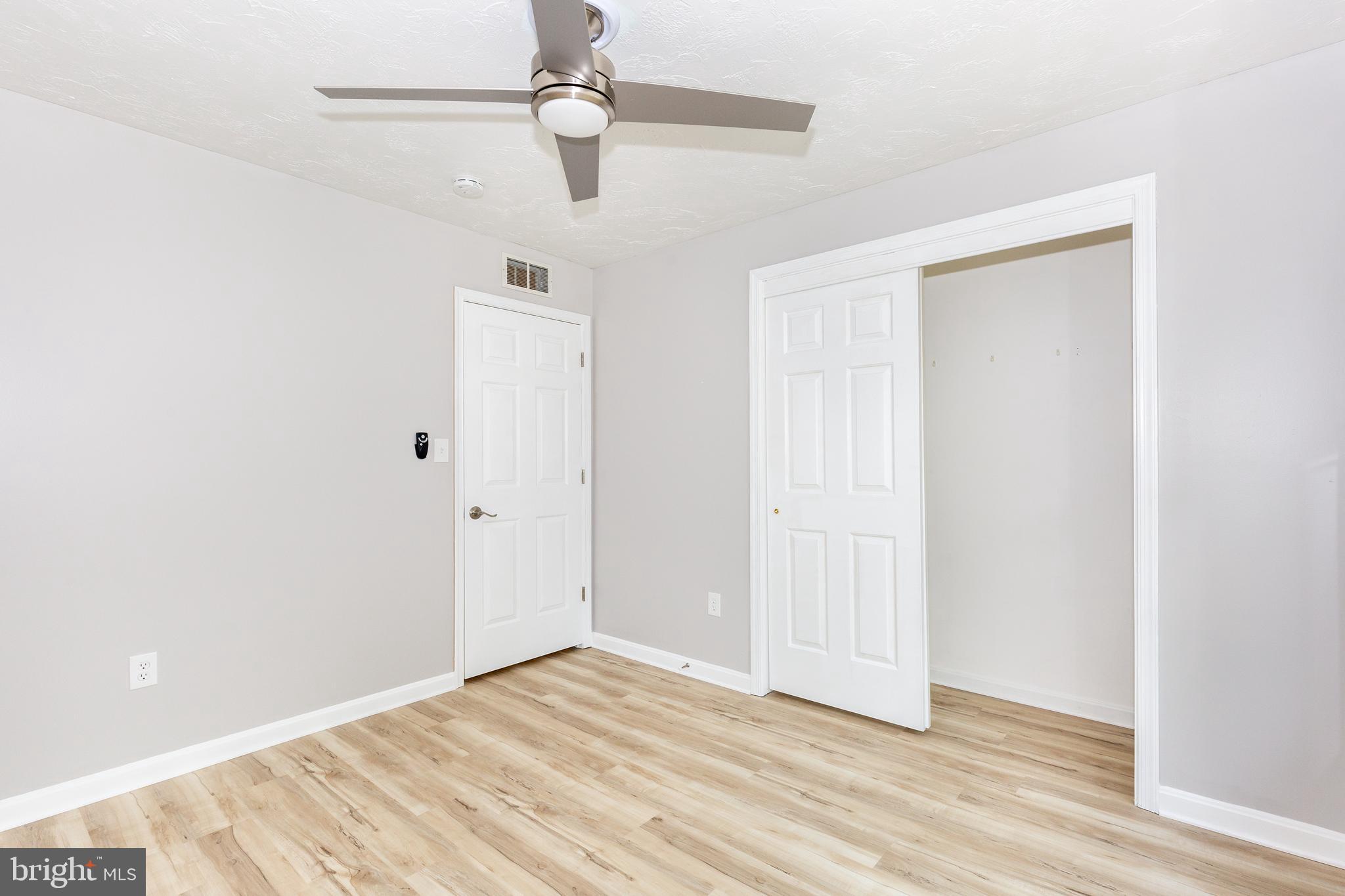 159 Colorado Avenue Littlestown, PA 17340 - Photo 31 of 47 an empty room with wooden floor ceiling fan and windows