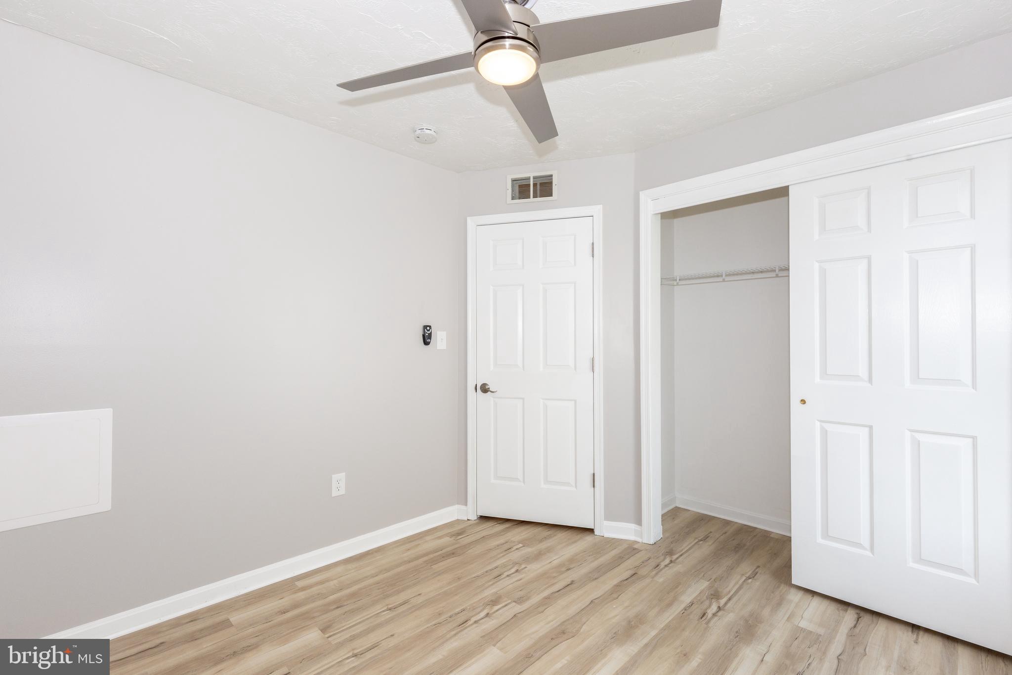 159 Colorado Avenue Littlestown, PA 17340 - Photo 34 of 47 an empty room with wooden floor ceiling fan and windows