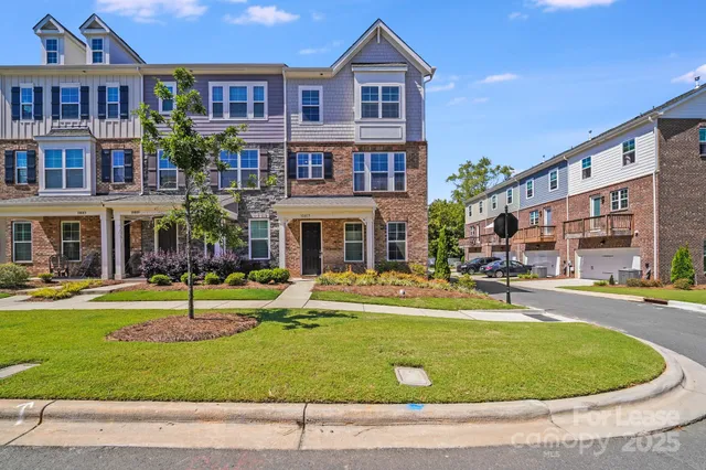 a view of an house with swimming pool and tall trees