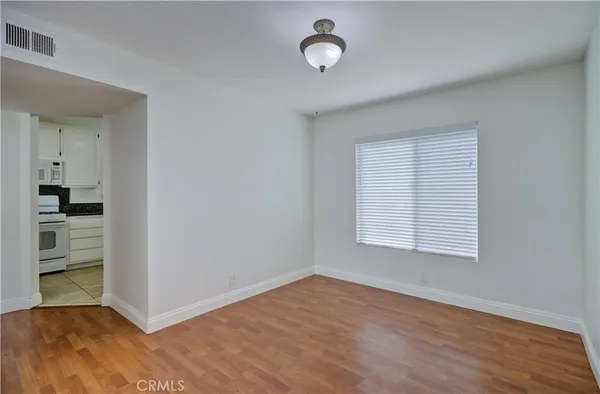 an empty room with wooden floor and mirror