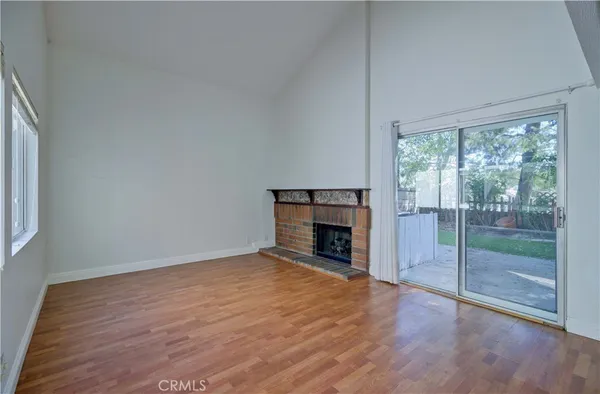 a view of empty room with wooden floor and fireplace