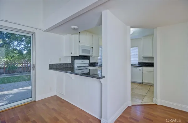 a kitchen with stainless steel appliances granite countertop a sink a stove and white cabinets