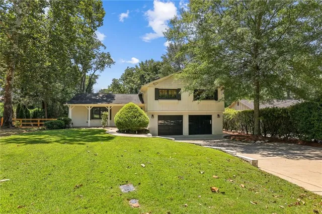 a front view of a house with a yard and trees