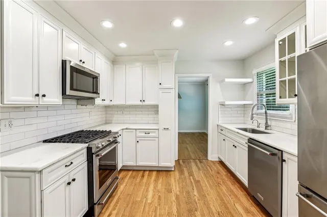 a kitchen with granite countertop cabinets stainless steel appliances and wooden floor