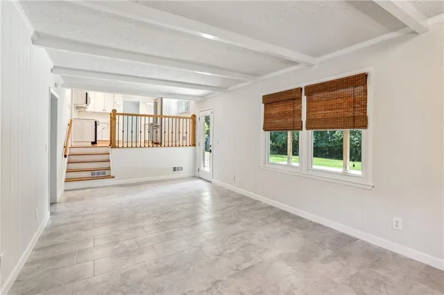 an empty room with a fireplace and windows