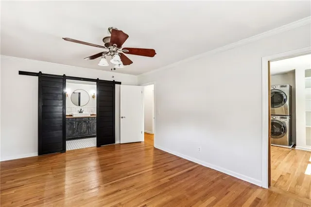 a view of a livingroom with a chandelier fan and wooden floor