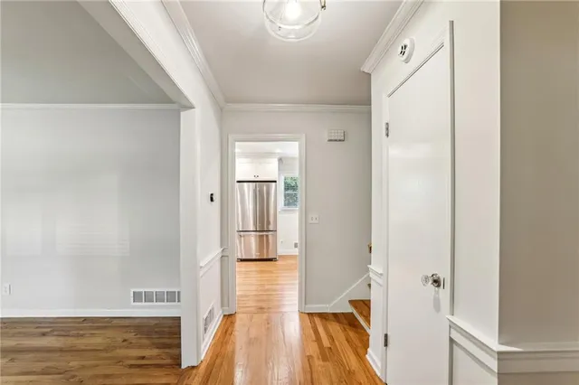 a view of a hallway with wooden floor and staircase