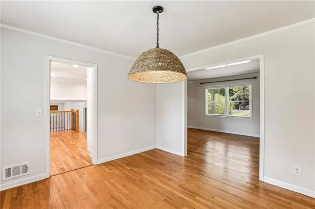 a view of a room with wooden floor chandelier and windows