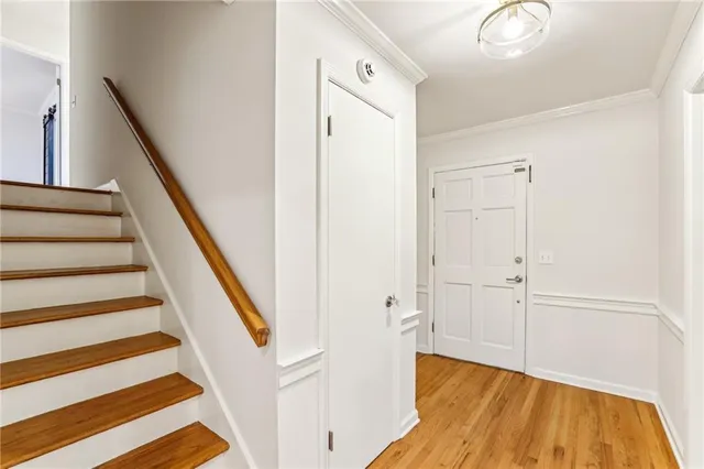 a view of a hallway with wooden floor and staircase