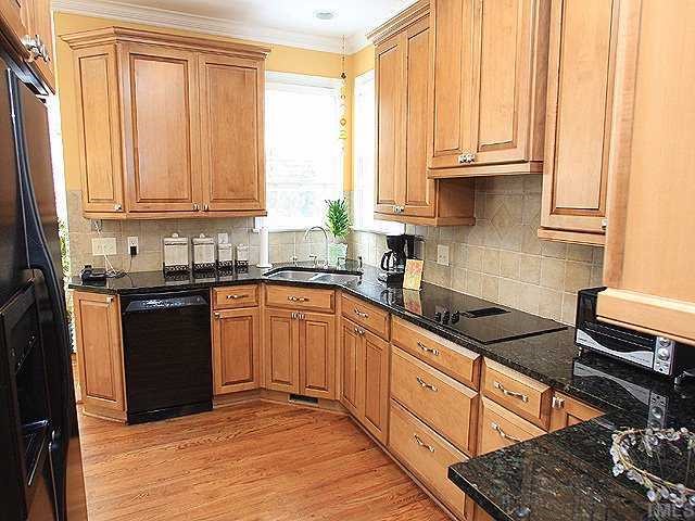 9117 Dawnshire Road Raleigh, NC 27615 - Photo 4 of 12 a kitchen with granite countertop a sink stainless steel appliances and cabinets