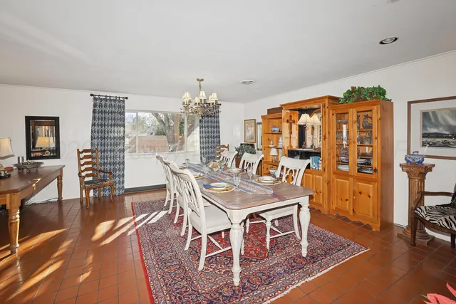 a dining room with wooden floor and chandelier