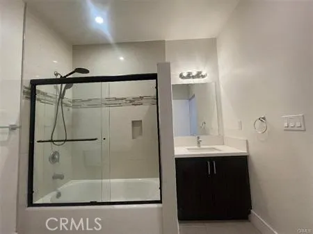 a bathroom with a sink a mirror and a glass door shower