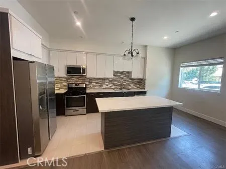 a kitchen with stainless steel appliances kitchen island granite countertop a sink stove and refrigerator