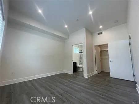 an empty room with wooden floor and entrance