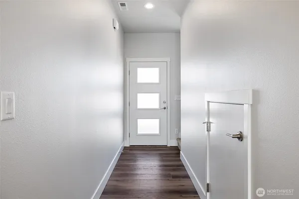 a view of a hallway with wooden floor and closet