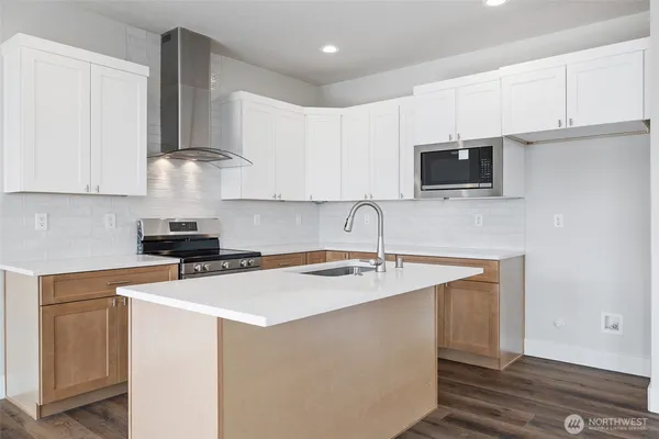 a kitchen with stainless steel appliances granite countertop a sink a stove top oven a counter space and cabinets