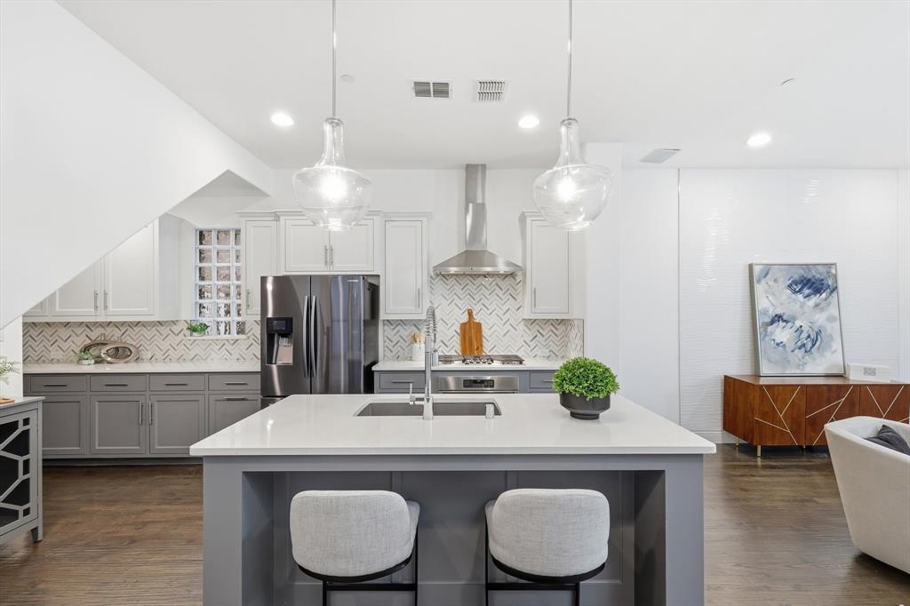 228 Skystone Drive Irving, TX 75038 - Photo 11 of 28 a kitchen with kitchen island a sink and chairs