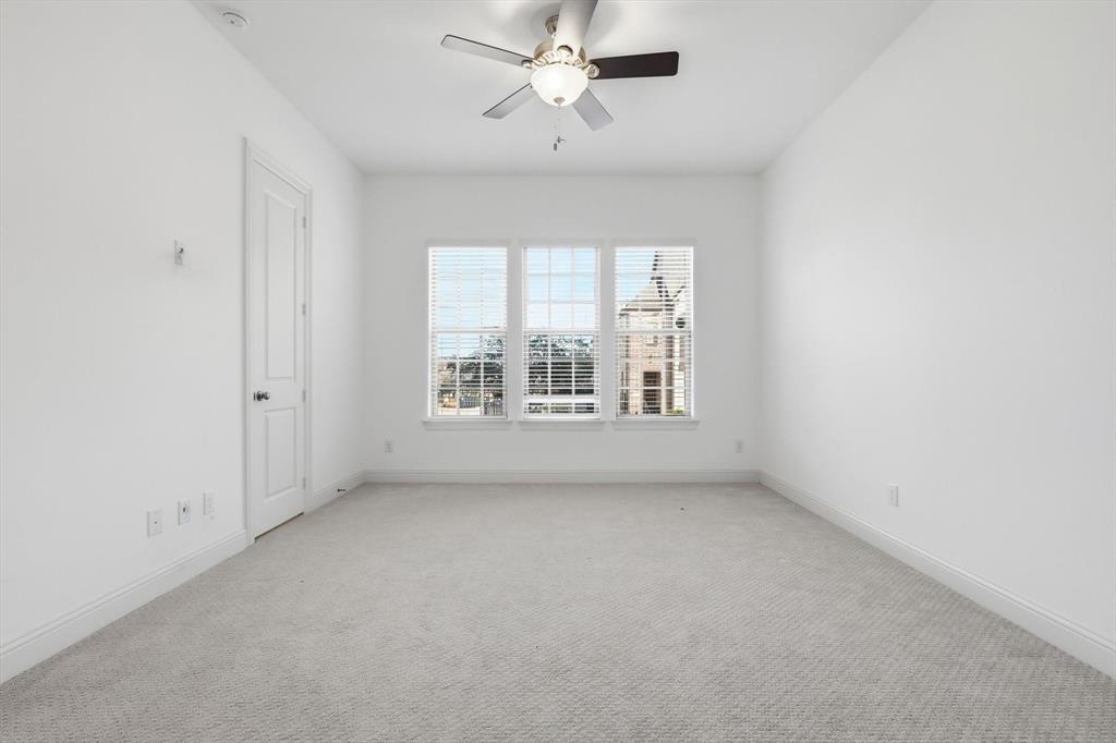228 Skystone Drive Irving, TX 75038 - Photo 20 of 28 an empty room with chandelier fan and windows