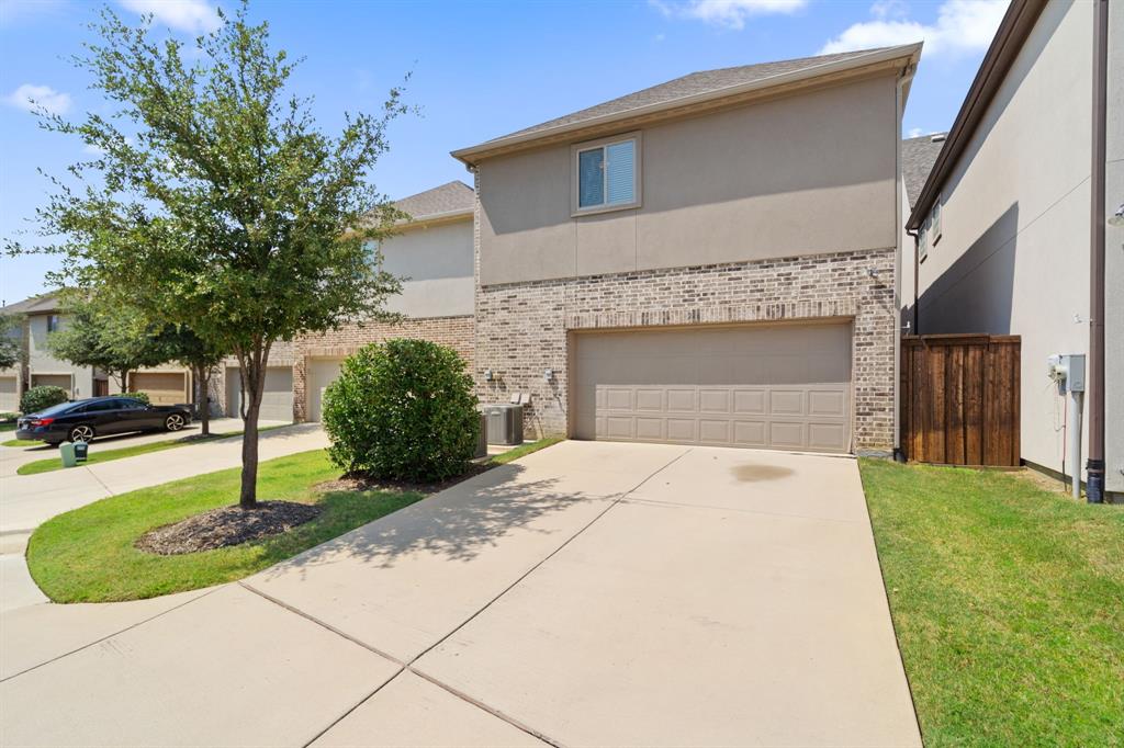228 Skystone Drive Irving, TX 75038 - Photo 26 of 28 a front view of a house with a garden and garage