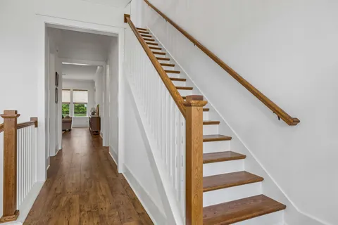 a view of a hallway with wooden floor and entryway