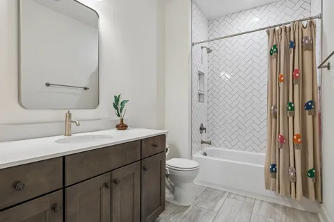 a bathroom with a bathtub shower sink vanity and toilet