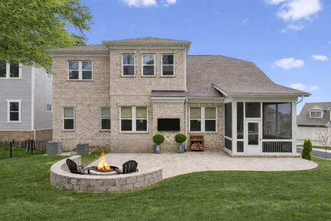 a front view of a house with a yard fire pit and outdoor seating