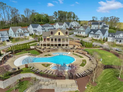 a view of a swimming pool with a yard and large tree